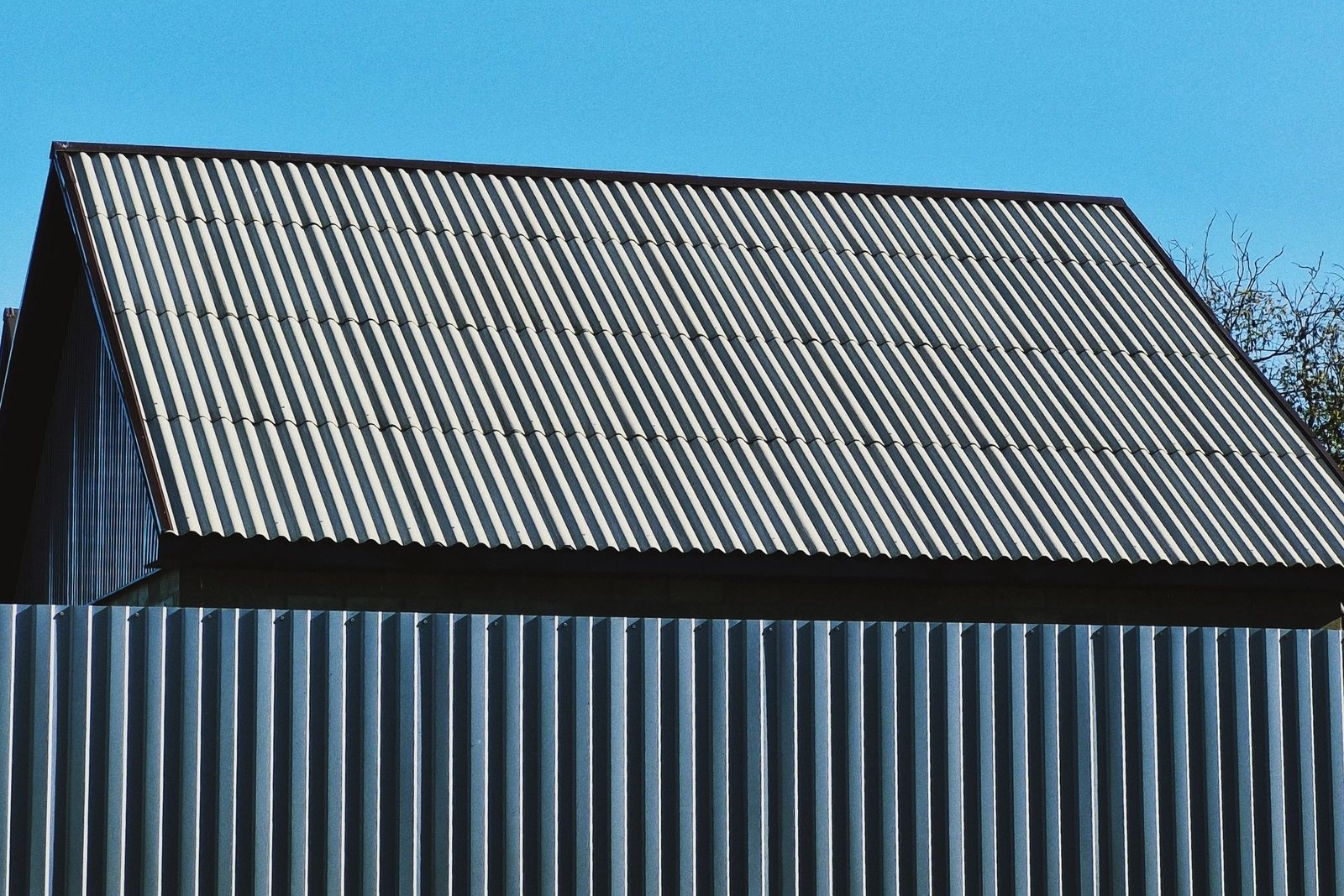 Corrugated metal roof panels on a barn against a clear sky